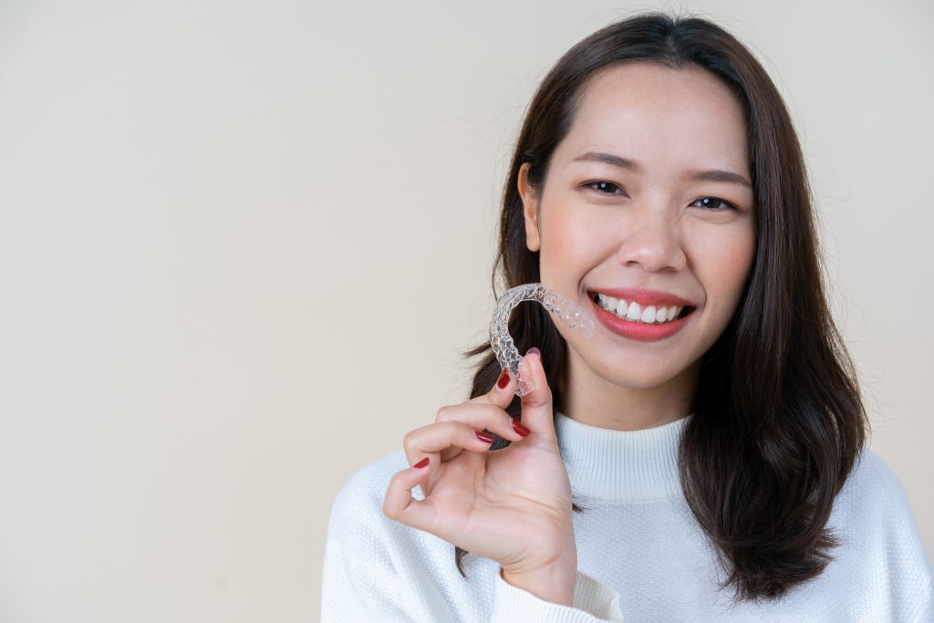 woman holding clear braces